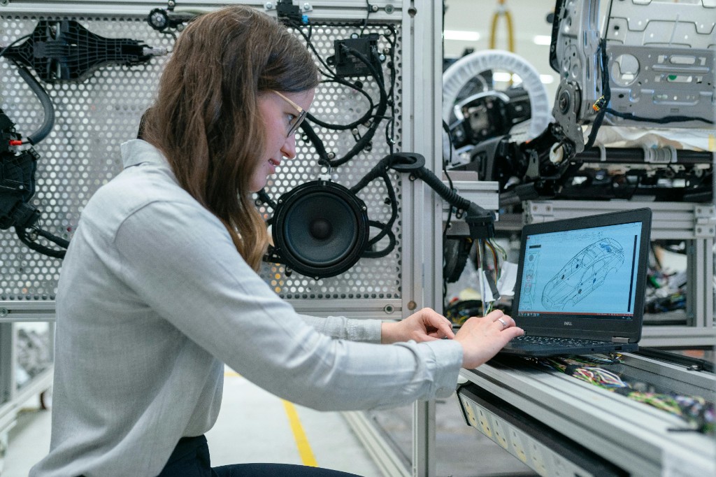 Engineer reviewing CAD model on a laptop in a prototyping bay